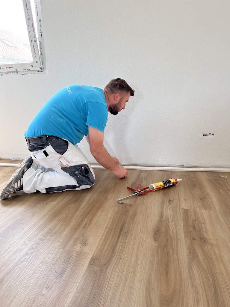 Sockelleisten-Montage auf Designboden in Holzoptik